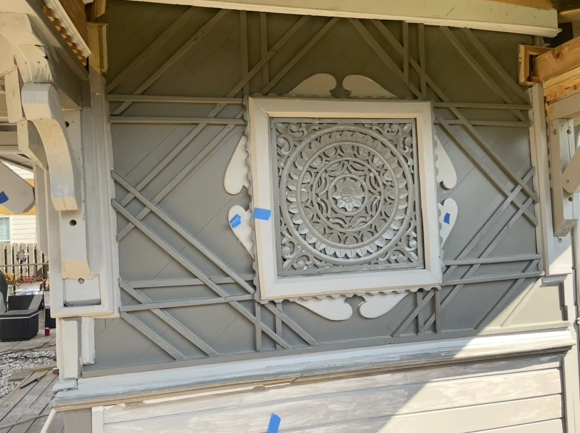 Exterior gable panel with angled slat pattern around a carved medallion