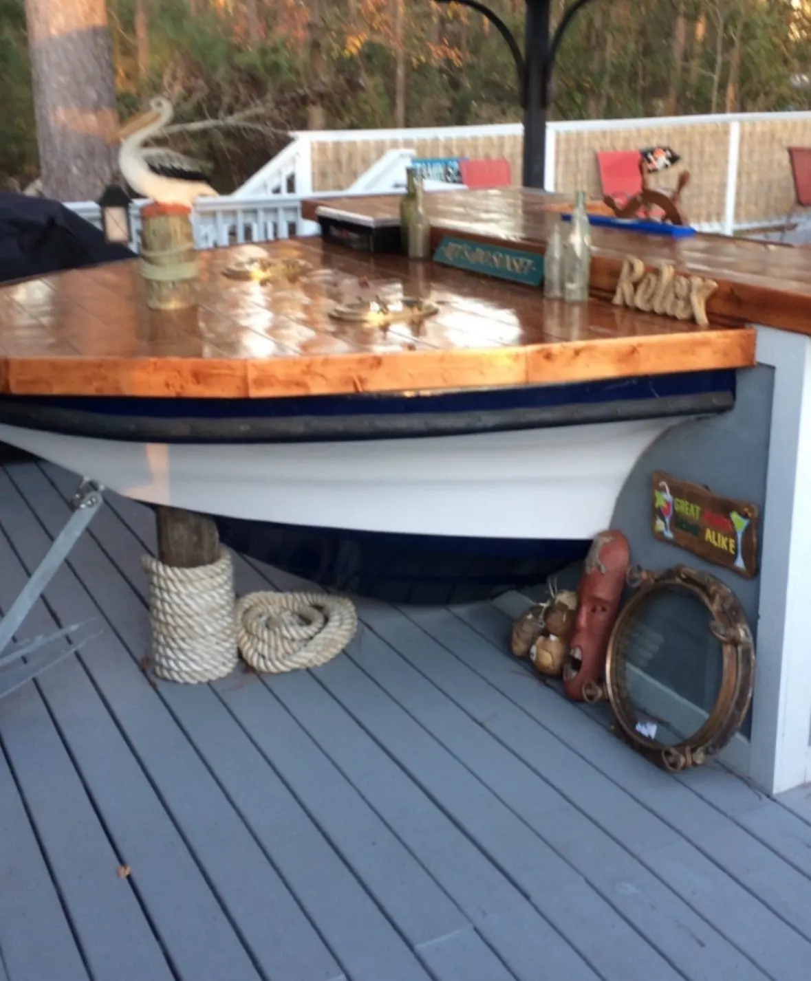Outdoor bar built into a boat hull with a glossy plank top, built by Severed Roots