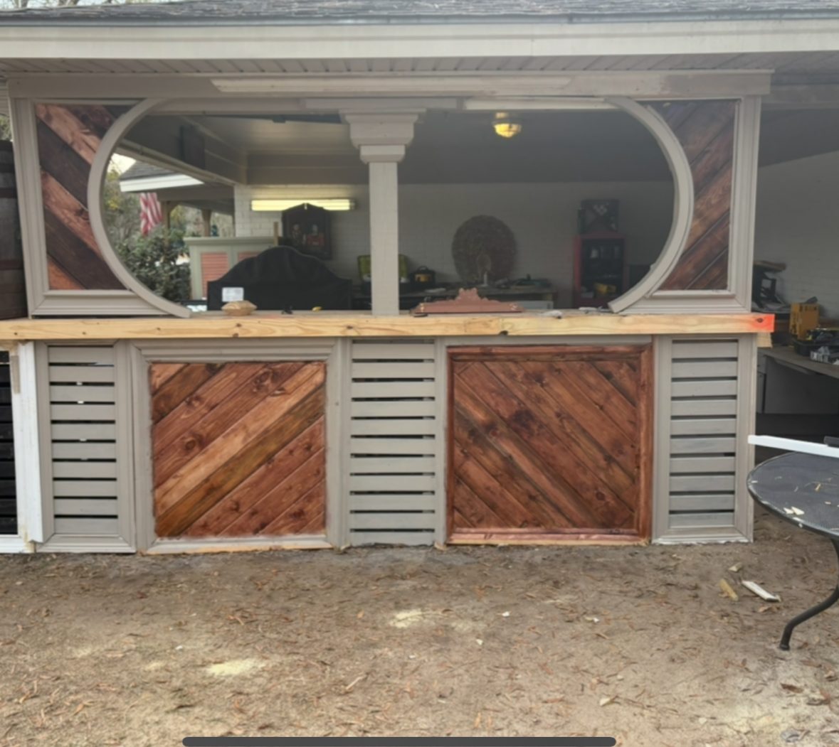 Built-in outdoor bar with oval pass-through and diagonal plank panels