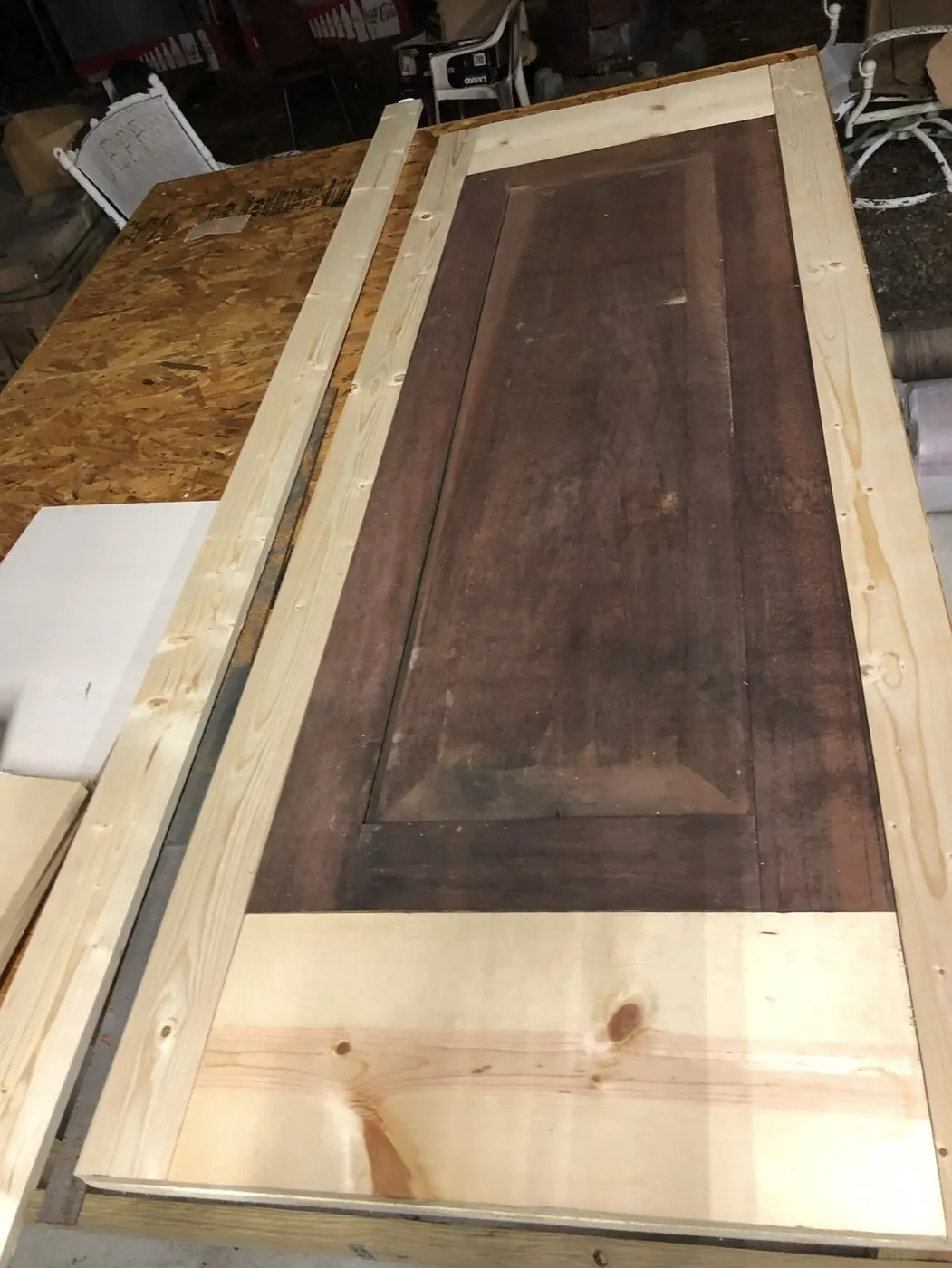 Salvaged raised panel fitted into the new frame, face down on the bench