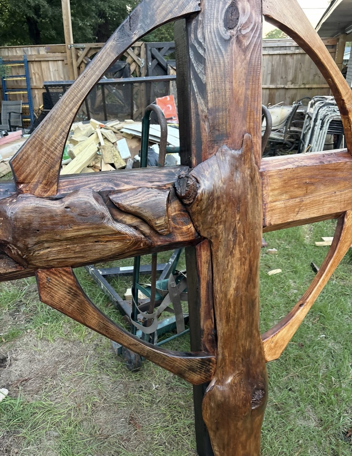 Carved cross and wheel detail in stained timber