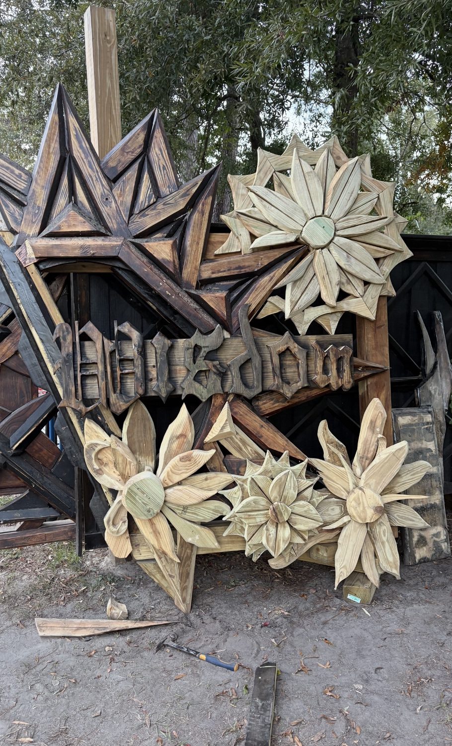 Large carved sign surrounded by wooden starbursts and florals