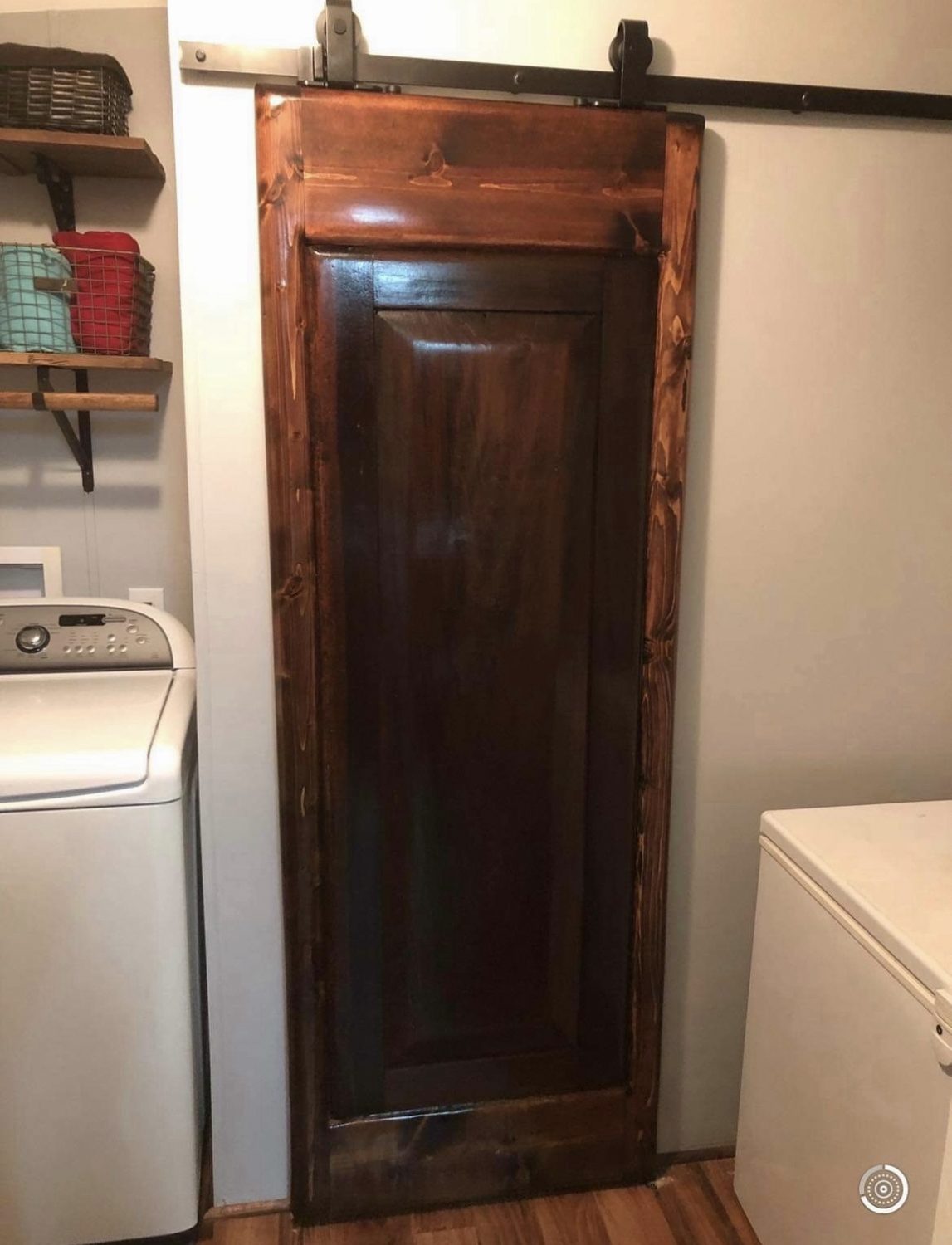 Stained sliding barn door on black track hardware