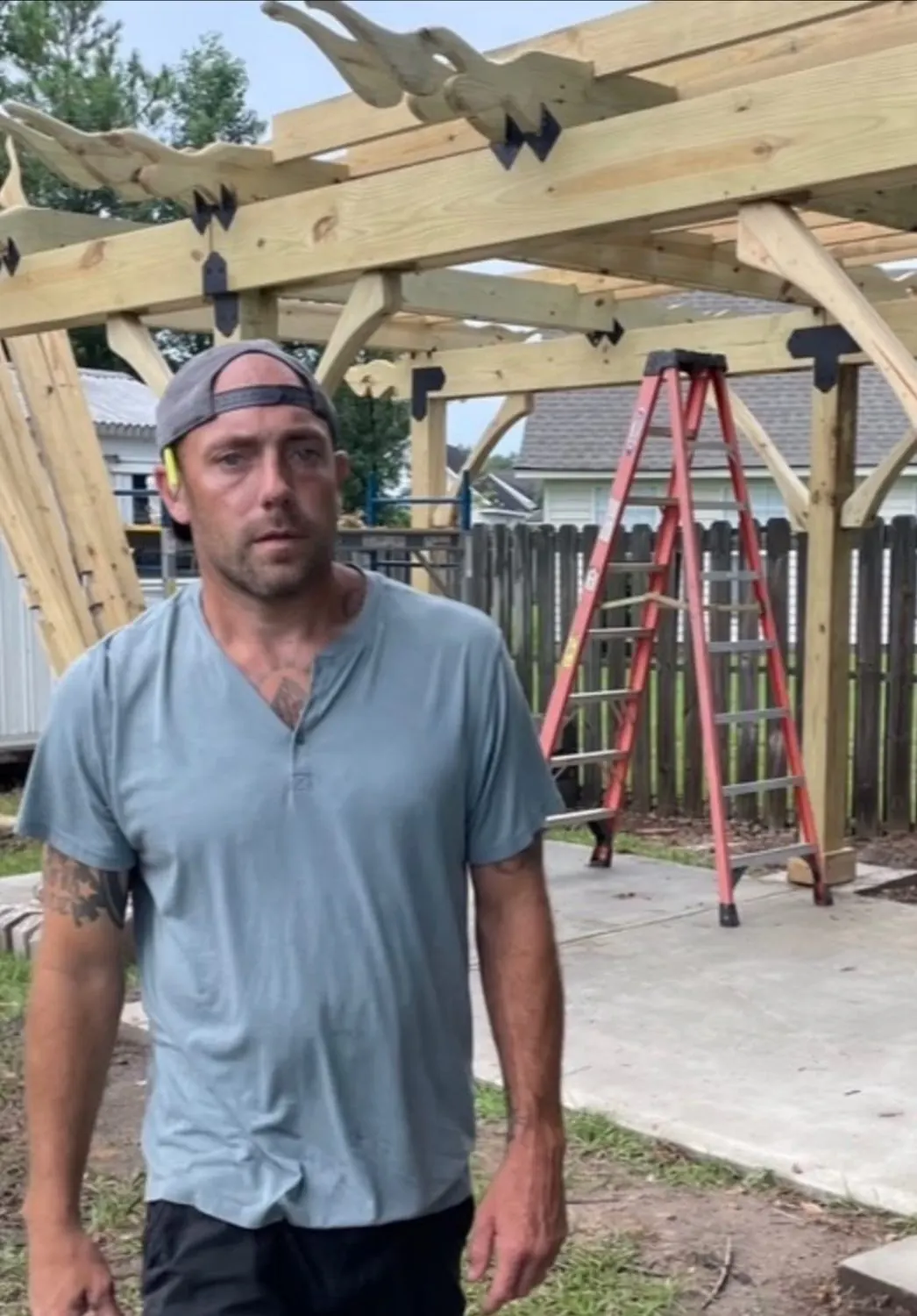 Daniel of Severed Roots in front of a timber pergola under construction