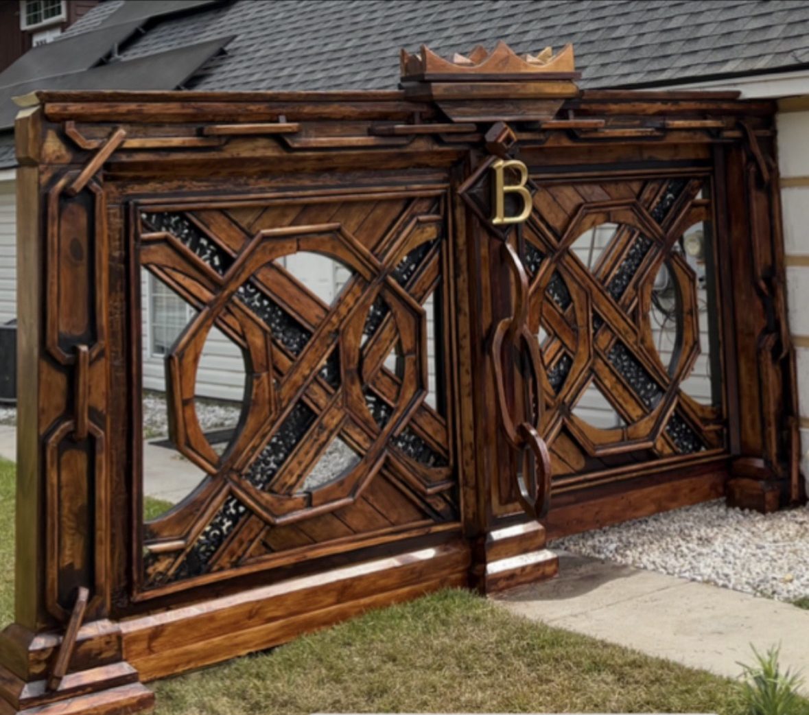 Custom wooden entry gate with interlocking octagon lattice, carved crown header and brass monogram