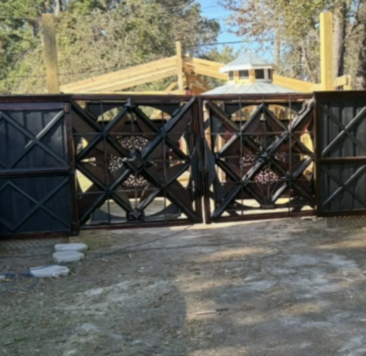 Pair of dark geometric wood driveway gates with matching fence panels