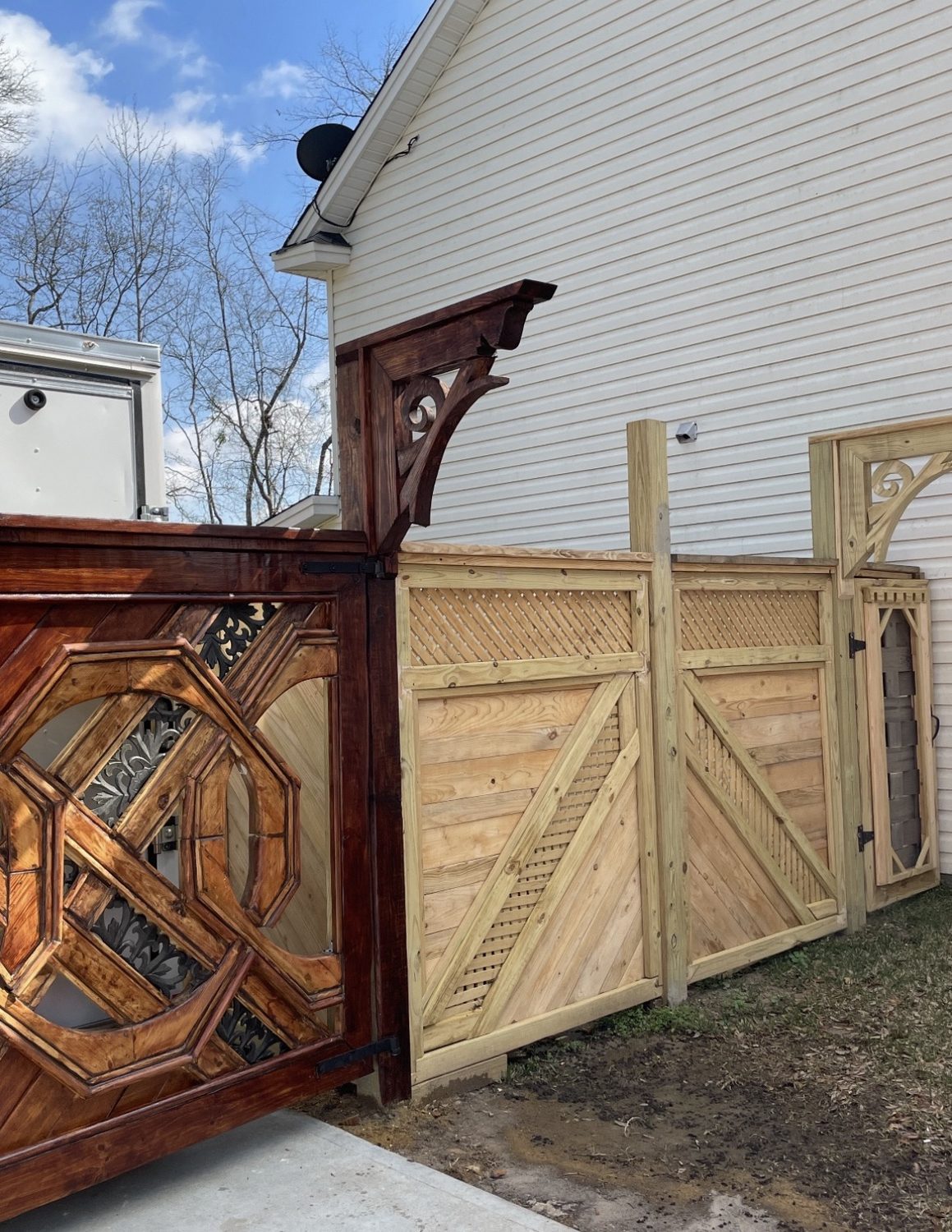 Stained gate beside matching lattice topped privacy fence panels
