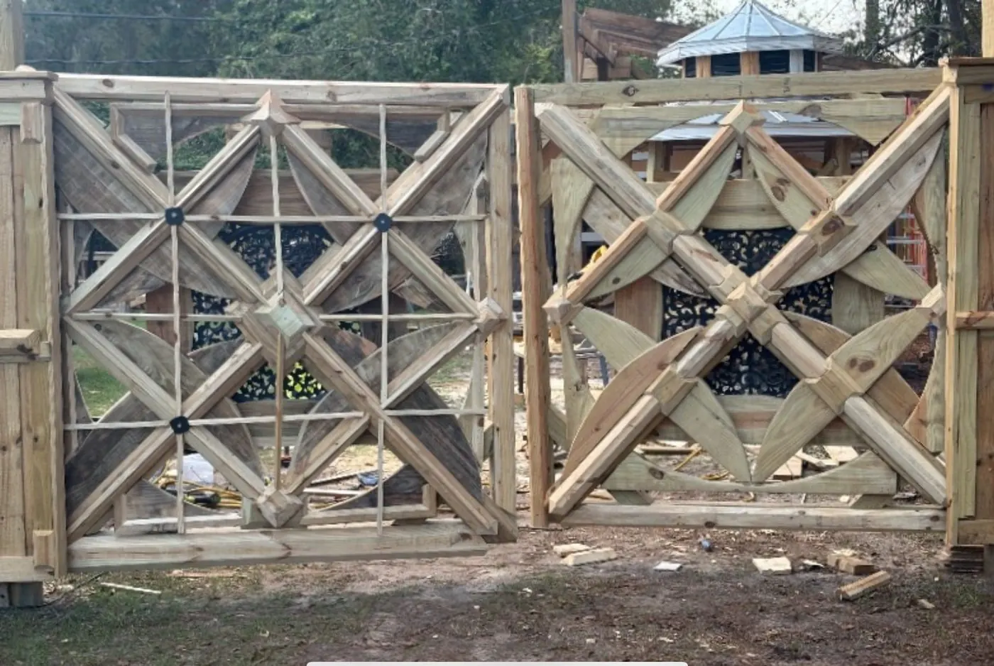 Pair of unstained X-pattern gate panels with iron inlay, in the shop