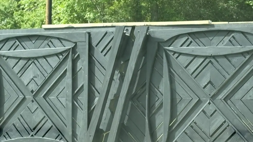 Black double gate with layered geometric panels and a split zigzag center seam