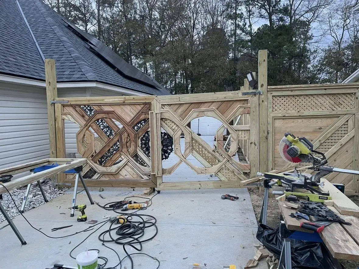 Raw gate pair hung between posts beside the house