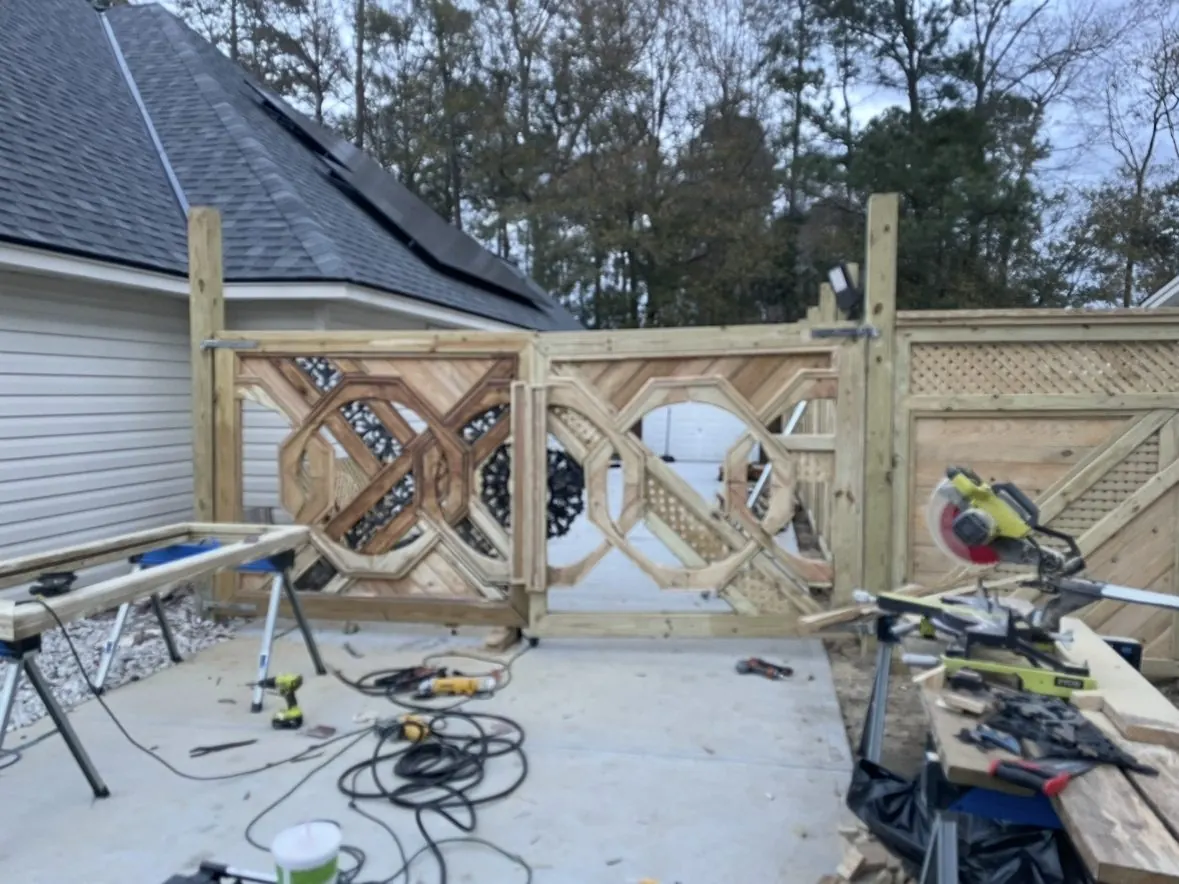 The same raw gates from the driveway, with the fence run alongside