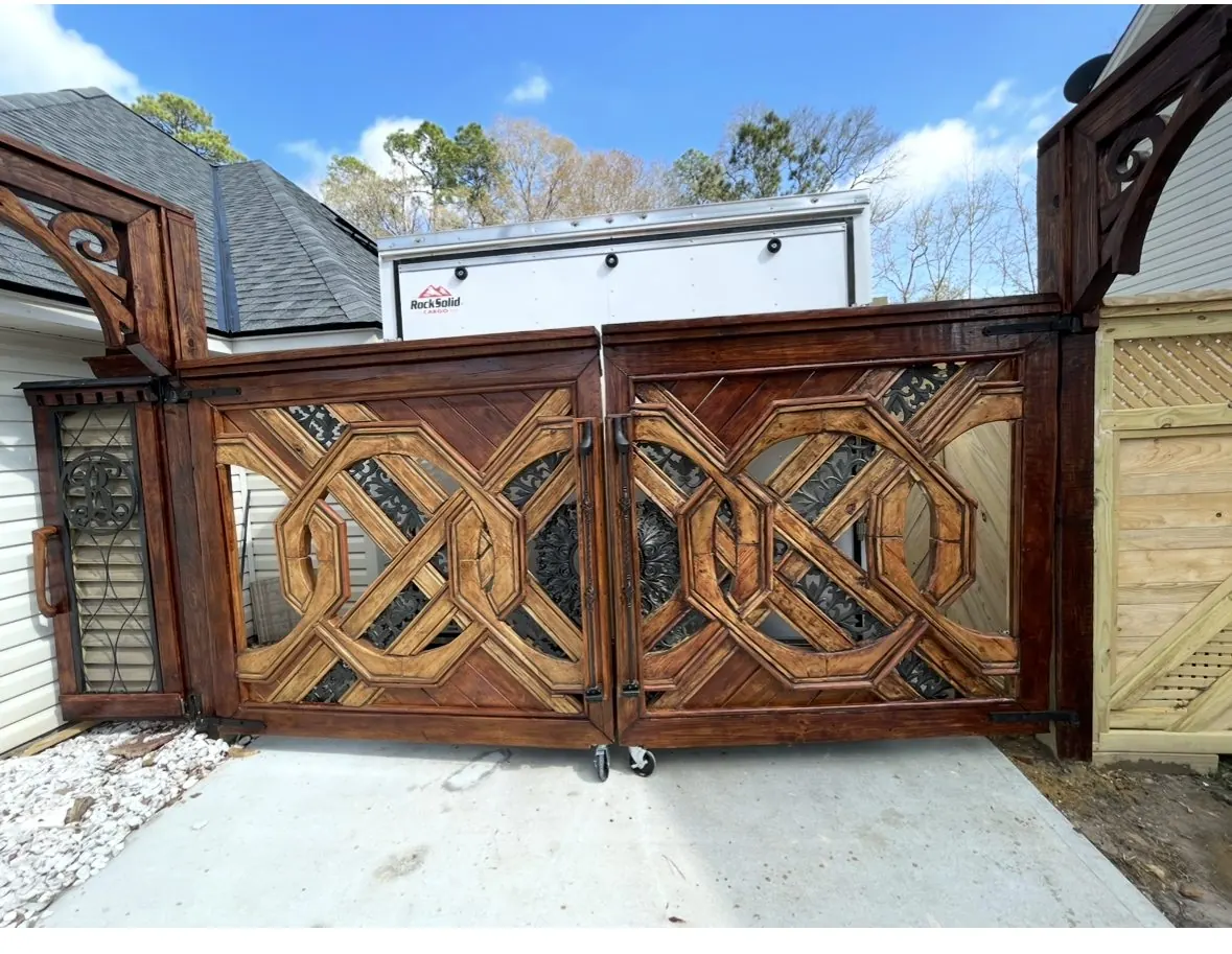 The finished gates in daylight with carved arch corbels above the posts