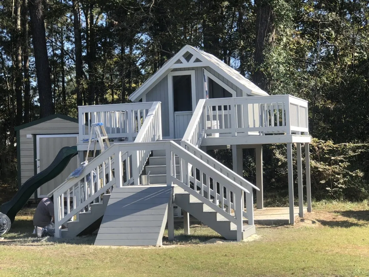Raised playhouse with deck, double stairs, ramp and slide