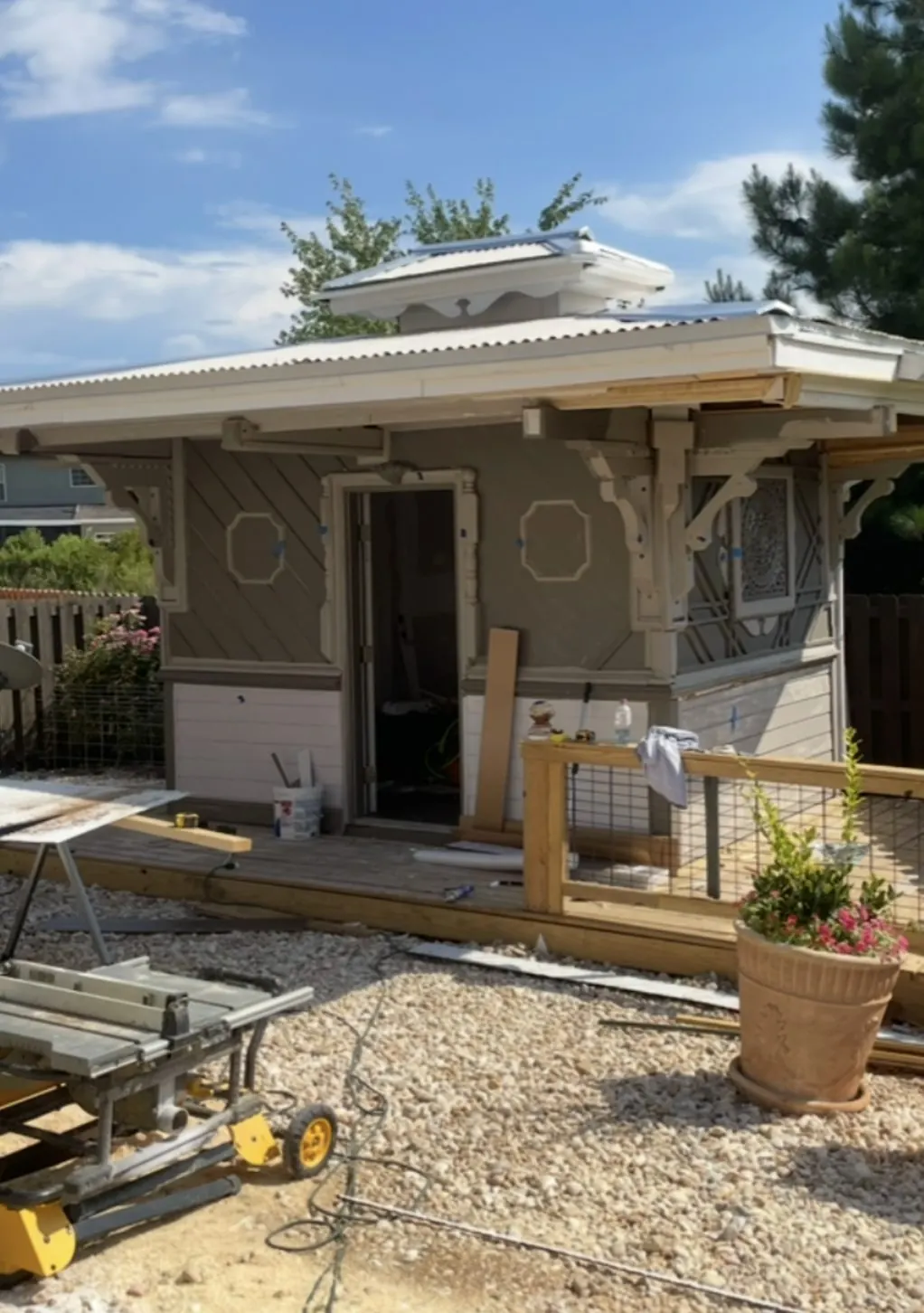 Outbuilding with carved brackets and window crowns, near completion