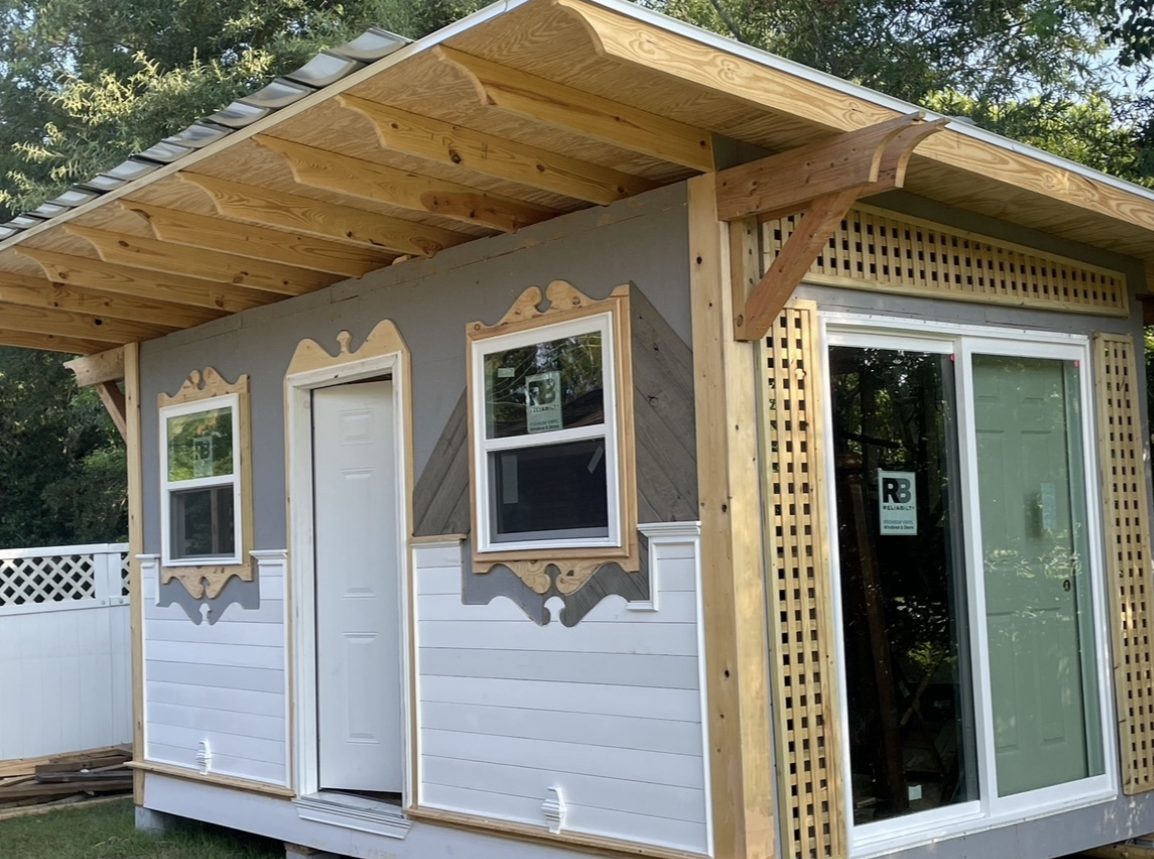 Studio building with carved trim, lattice detail and metal roof