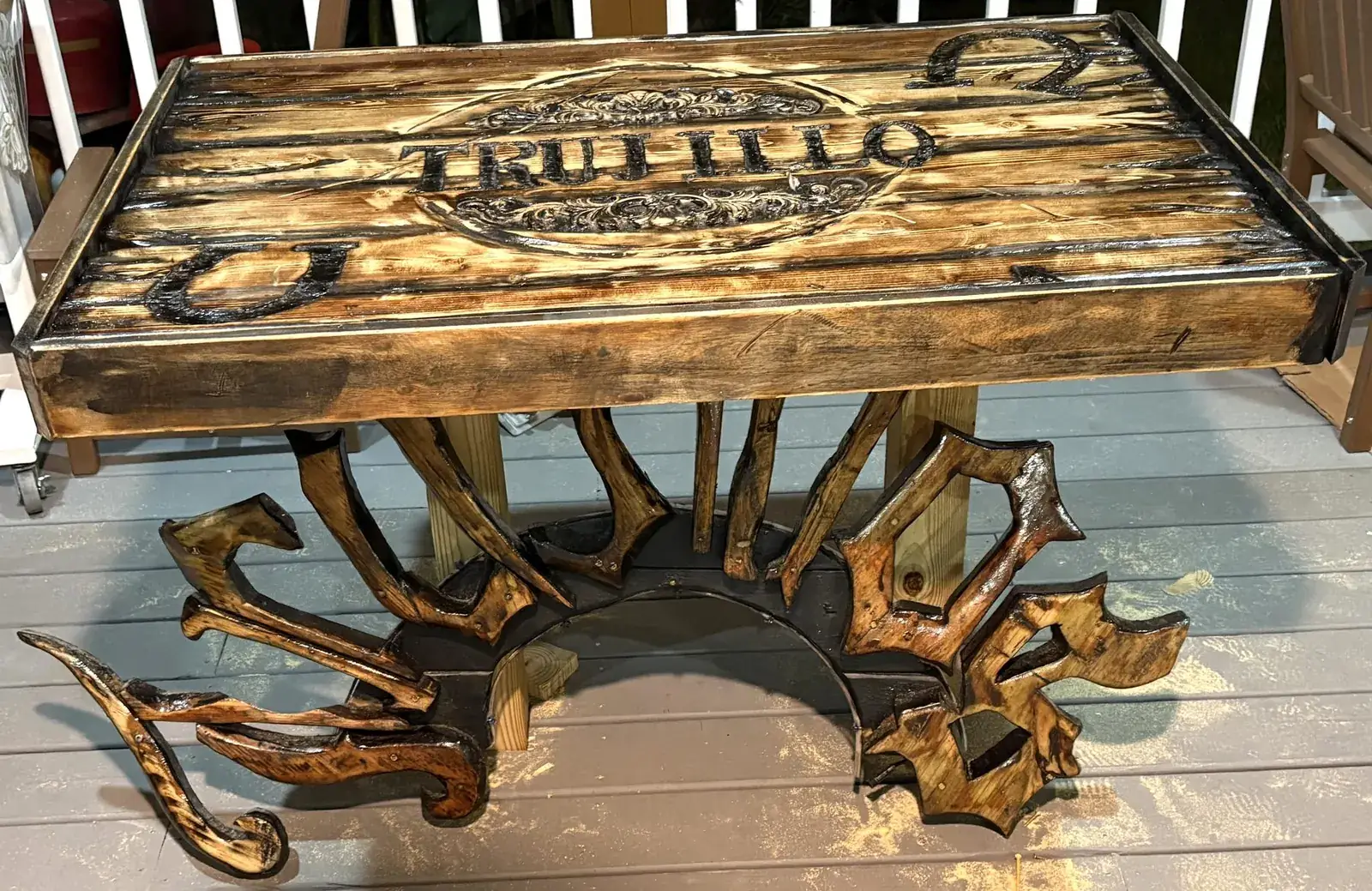 Carved family name table with a sculpted letterform base
